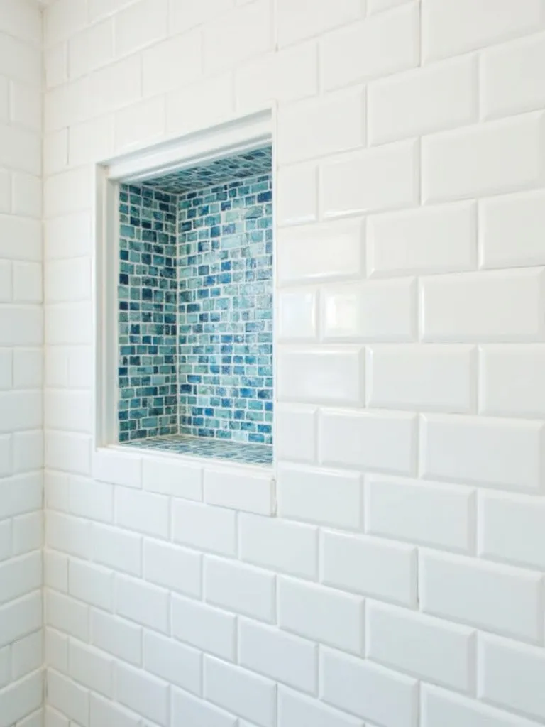 Modern bathroom shower with a niche tiled in blue mosaic tiles, adding a functional and decorative element.