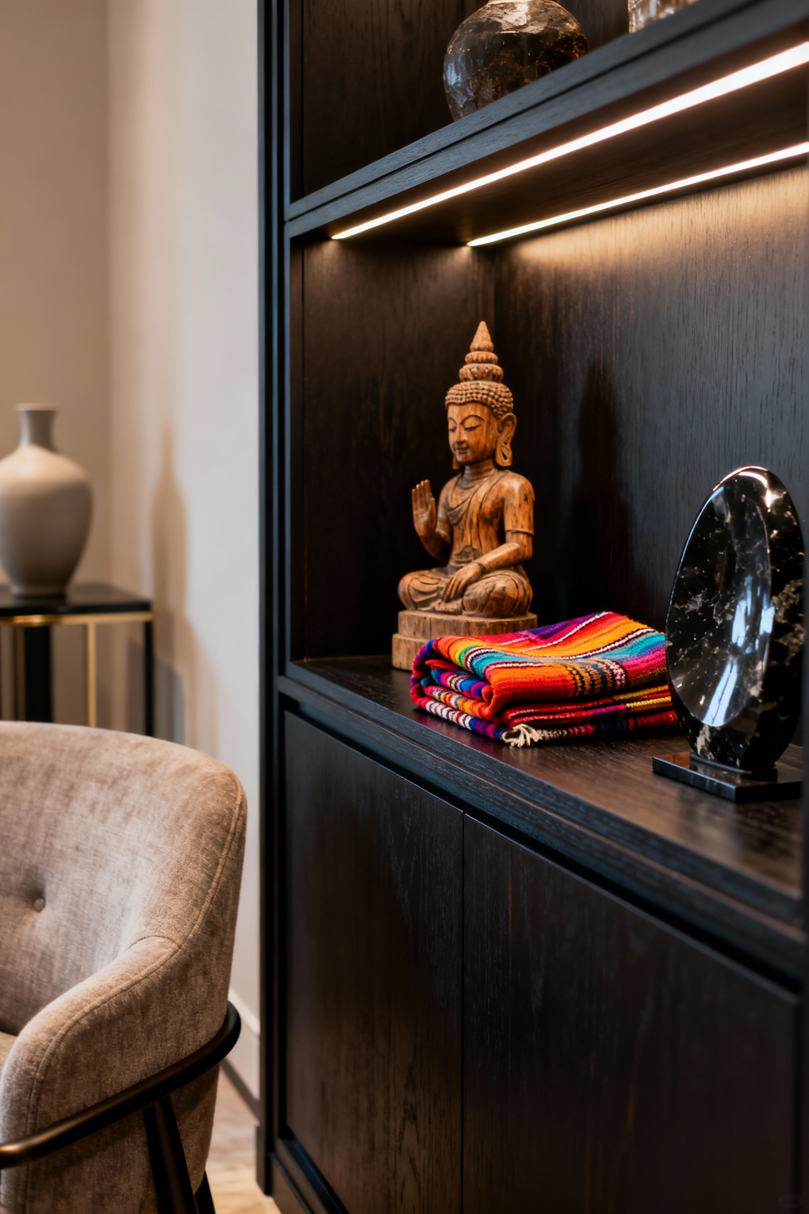 Luxury living room vignette with carefully curated global travel mementos displayed in a bespoke vitrine and custom shelving, accent lighting, sophisticated decor.