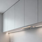 A sleek modern kitchen featuring flat-panel cabinet doors in a matte finish, emphasizing uninterrupted visual flow and the discreet integration of smart technology for a future-forward design.