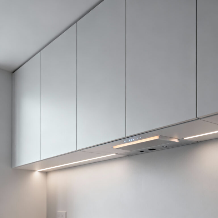 A sleek modern kitchen featuring flat-panel cabinet doors in a matte finish, emphasizing uninterrupted visual flow and the discreet integration of smart technology for a future-forward design.